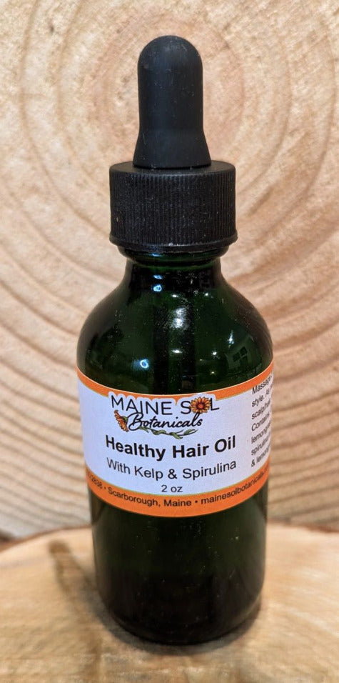 Bottle of Maine Sol Botanicals Healthy Hair Oil with Kelp & Spirulina on a wooden surface