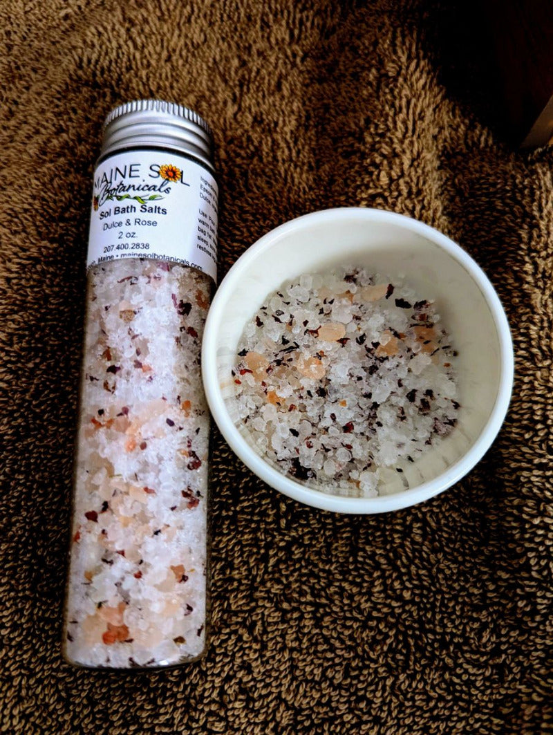 Bottle and bowl of bath salts on a textured surface