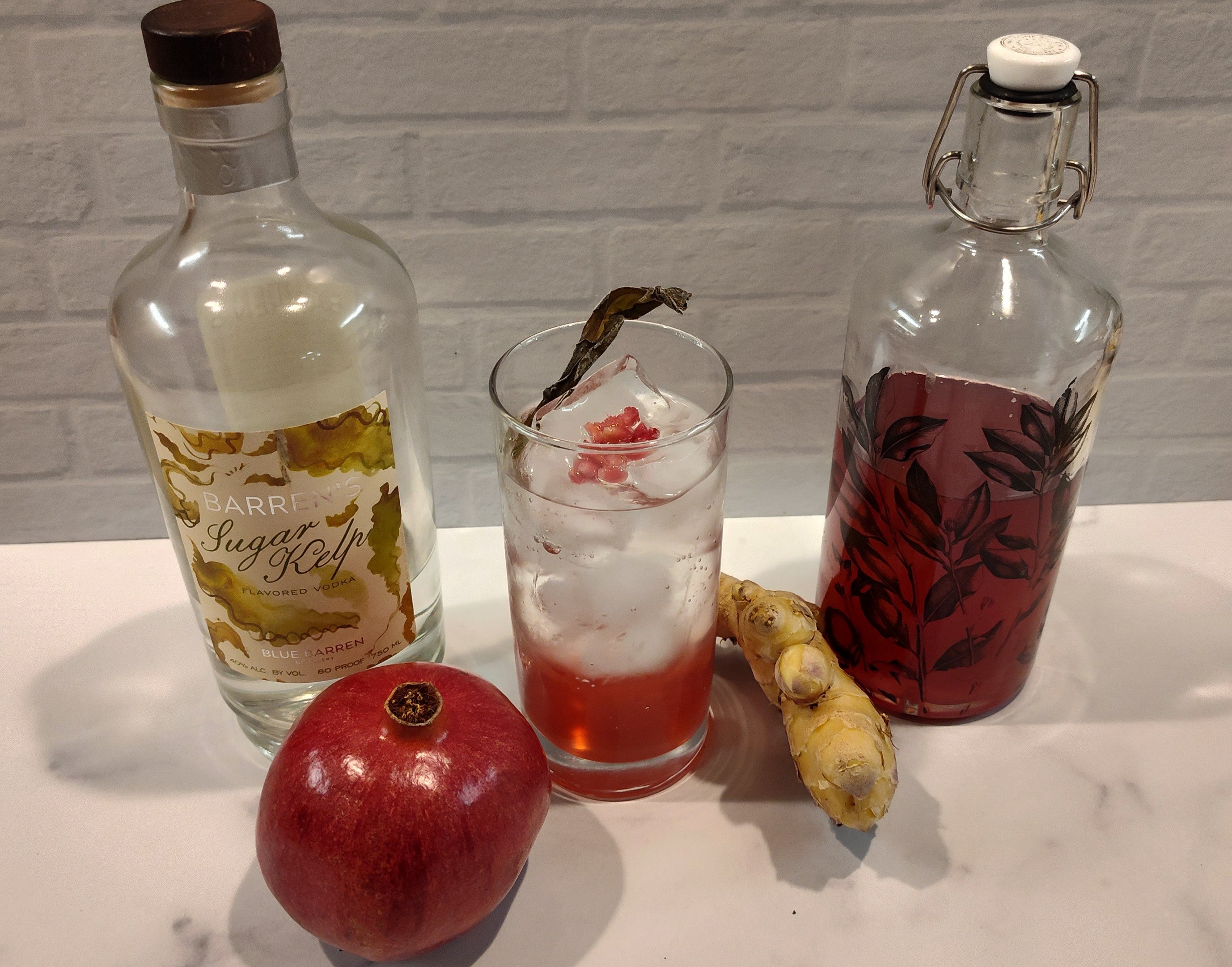 Pomegranate, ginger, shrub bottle, and cocktail