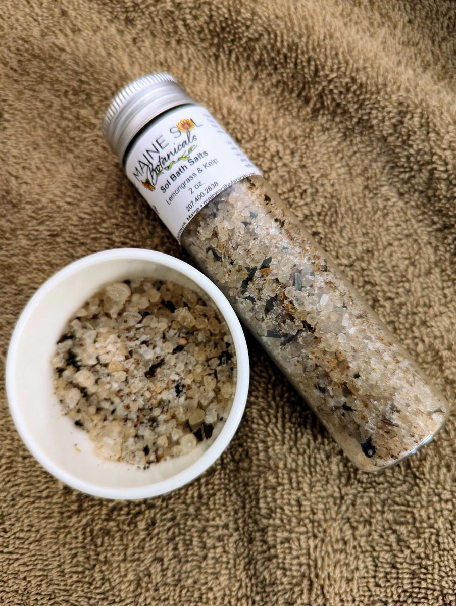 Bottle and bowl of bath salts on a brown towel